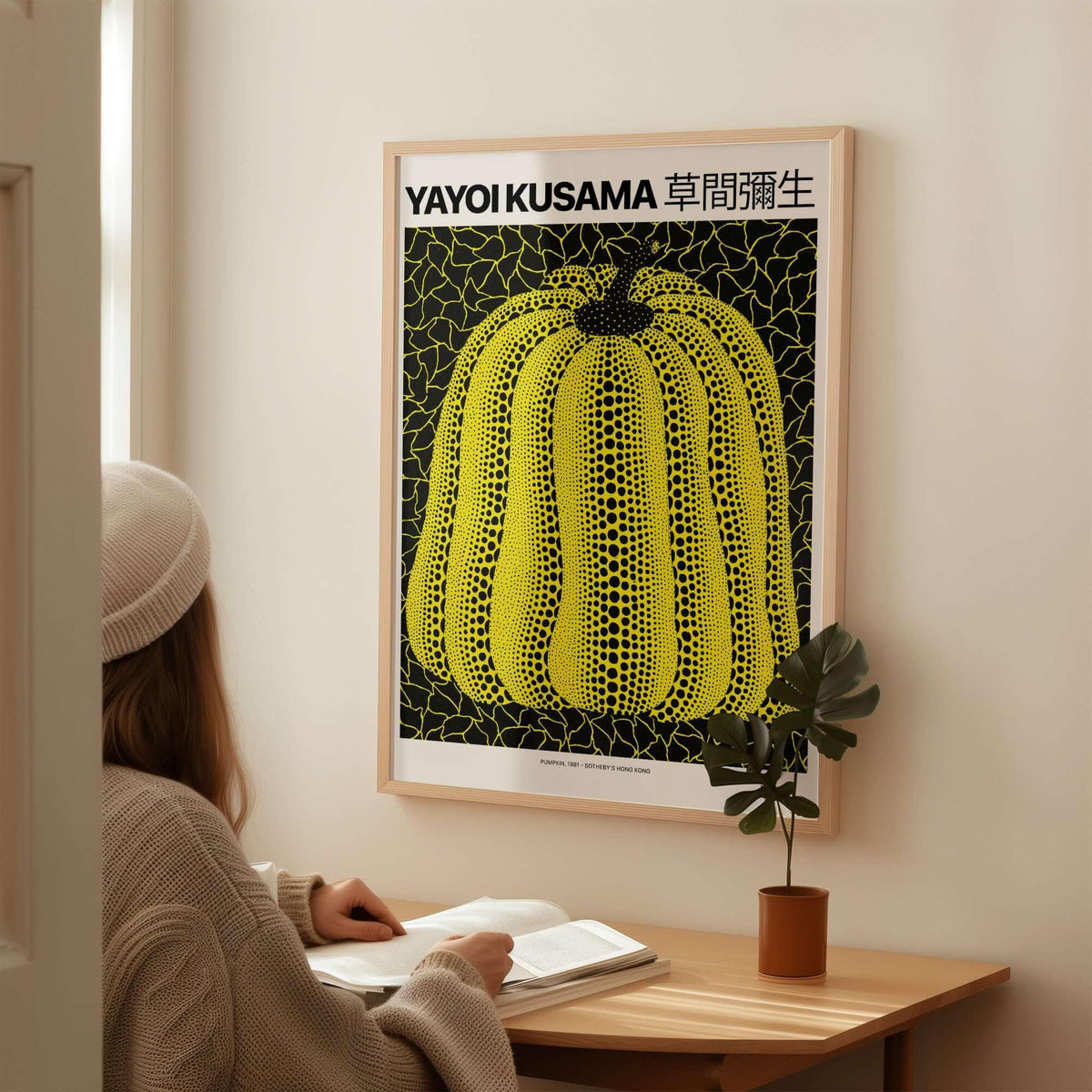 Yayoi Kusama Yellow Black Pumpkin 1991 Hong Kong Art Print Poster Polka Dot Decor framed in room with a person reading.