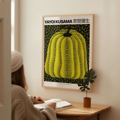 Yayoi Kusama Yellow Black Pumpkin 1991 Hong Kong Art Print Poster Polka Dot Decor framed in room with a person reading.