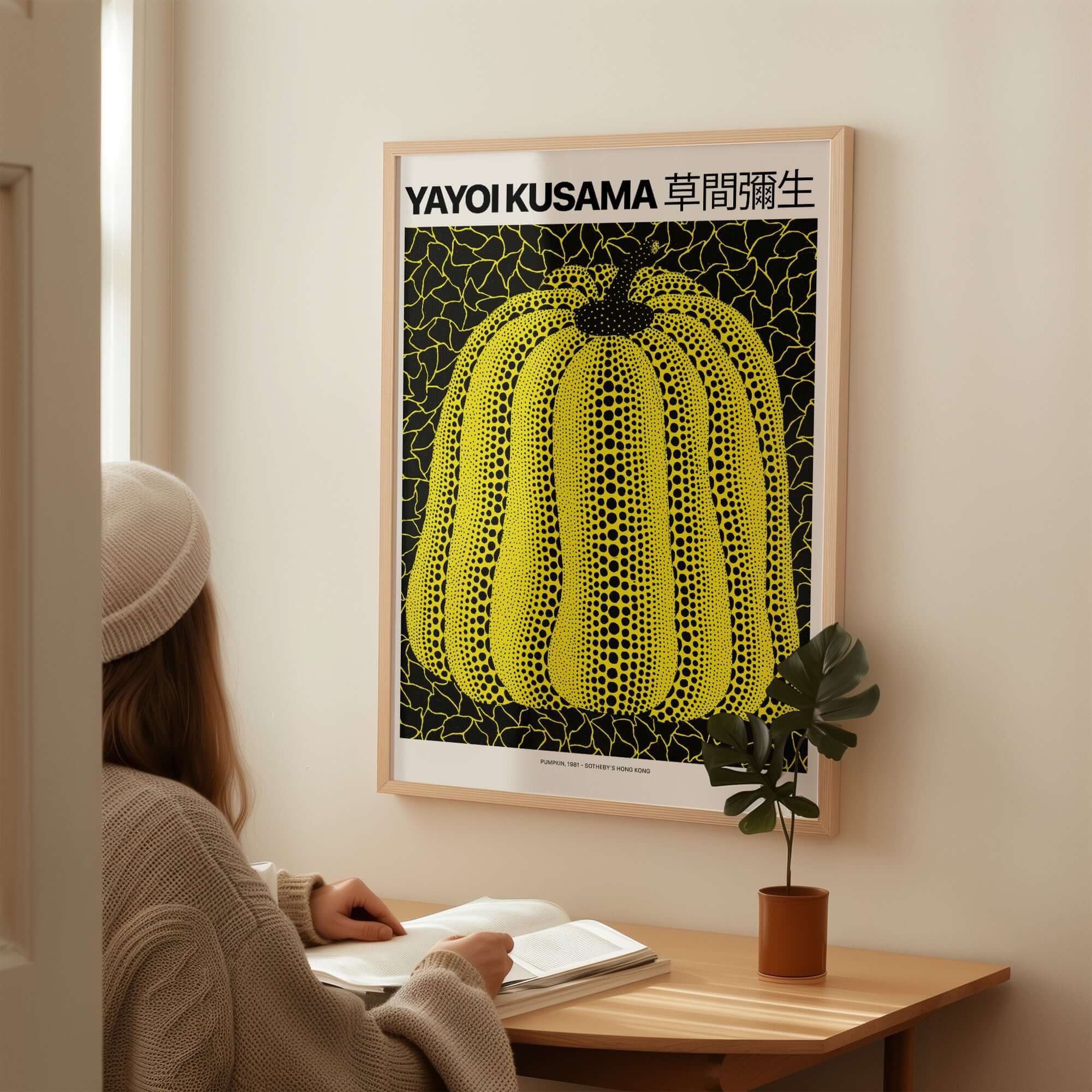 Yayoi Kusama Yellow Black Pumpkin 1991 Hong Kong Art Print Poster Polka Dot Decor framed in room with a person reading.