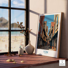 York England Medieval Alley Poster - UK Travel Destination Decor displayed on a window sill with beach view.