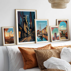 York England Shambles Print - Illuminated York Alleyway Wall Art displayed among other travel art prints on a cozy couch.