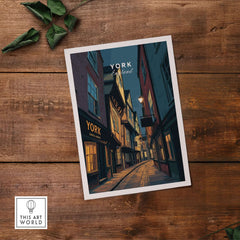York England Shambles Print - Illuminated York Alleyway Wall Art on a wooden table with green foliage.