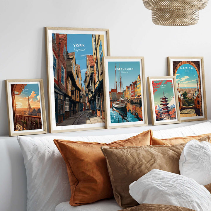 Framed prints of historic city scenes including York, Copenhagen, and Barcelona on a stylish sofa.