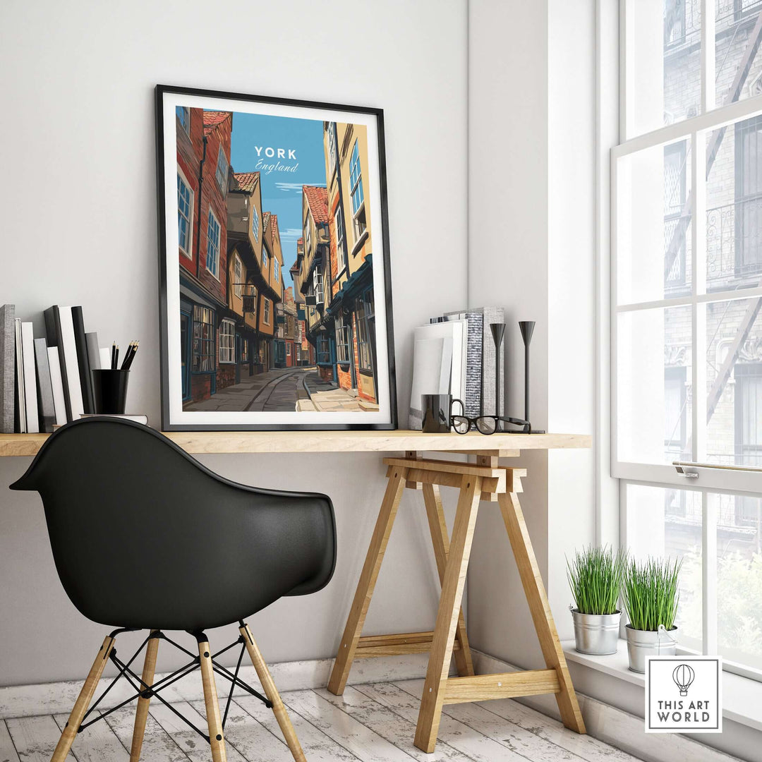 Framed print of The Shambles in York, England, displayed in a modern home office with a stylish chair and scenery.