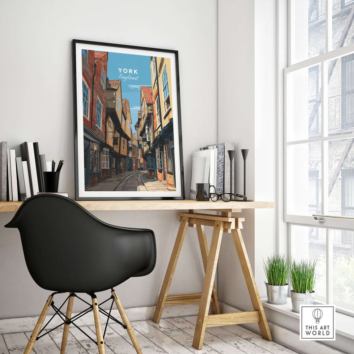 Framed print of The Shambles in York, England, displayed in a modern home office with a stylish chair and scenery.