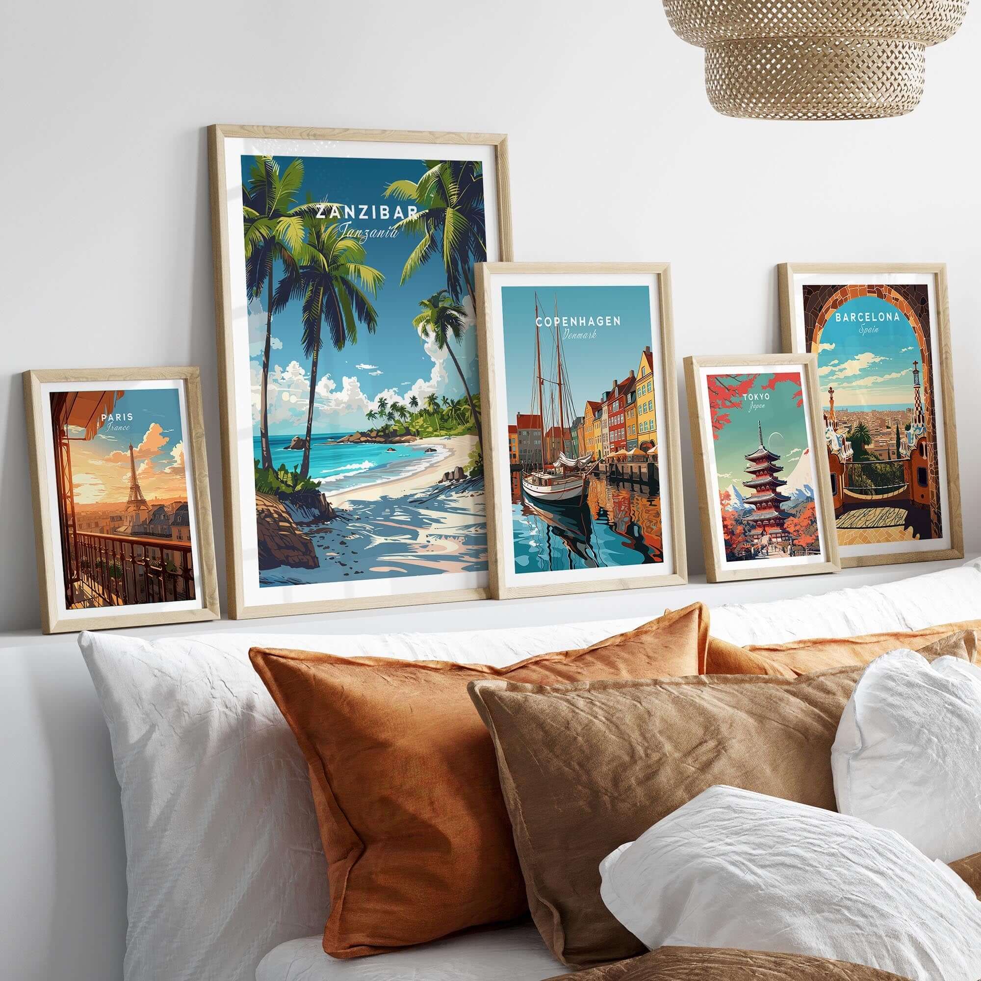 Zanzibar Wall Art Print displayed with travel posters of Copenhagen and Barcelona on a stylish bed.
