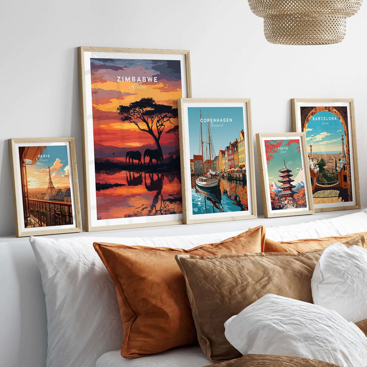 Framed travel posters including a Zimbabwe elephant print, displayed on a cozy sofa with decorative pillows.