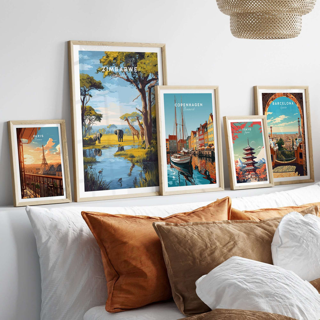 Gallery display of travel prints, including a Zimbabwe savanna landscape poster, on a cozy sofa backdrop.
