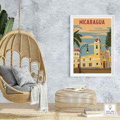 Colorful Nicaragua poster featuring vintage architecture, framed art in a stylish home setting with wicker chair.