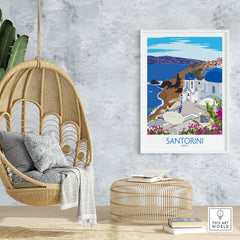 Santorini print travel poster displayed in a stylish interior with hanging chair and decorative elements.