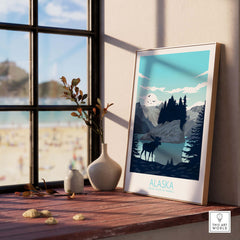 Alaska travel poster print featuring mountains and moose, displayed on a windowsill with beach view.
