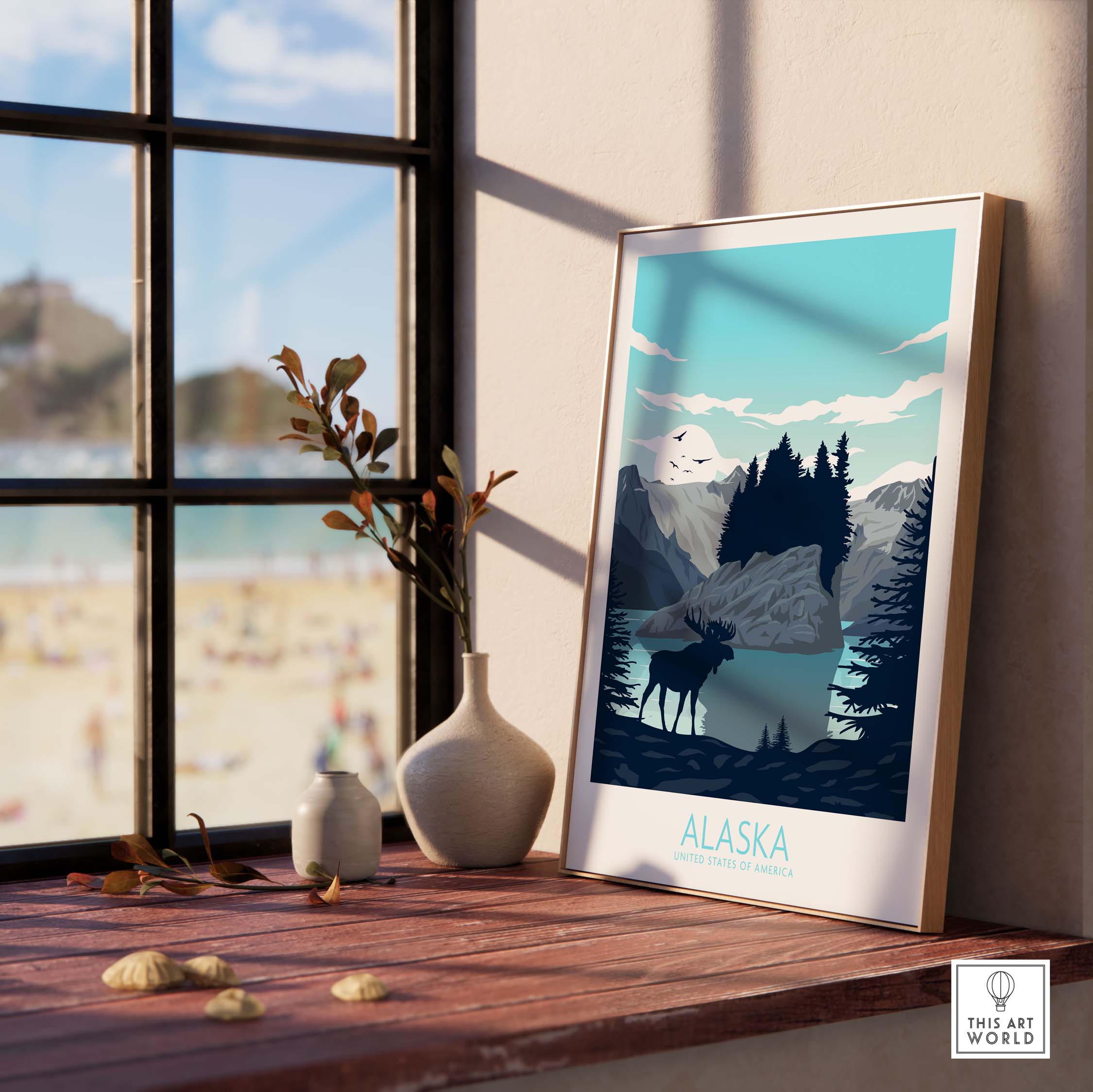 Alaska travel poster print featuring mountains and moose, displayed on a windowsill with beach view.