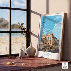 Athens Greece wall art poster displayed on a wooden table by a window, featuring the Parthenon in a minimalist vintage style.