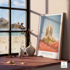 Barcelona wall art print featuring Sagrada Familia displayed on a shelf near a window with beach scenery.