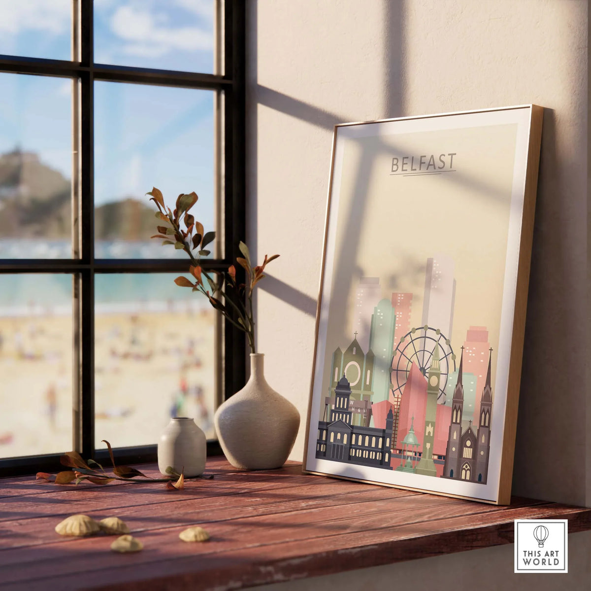 Belfast skyline print in pastel tones displayed on a wooden table near a sunlit window, showcasing Northern Ireland's architecture.