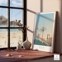 Stylish Berlin poster print on a wooden table, featuring iconic landmarks, perfect for home decor and travel enthusiasts.