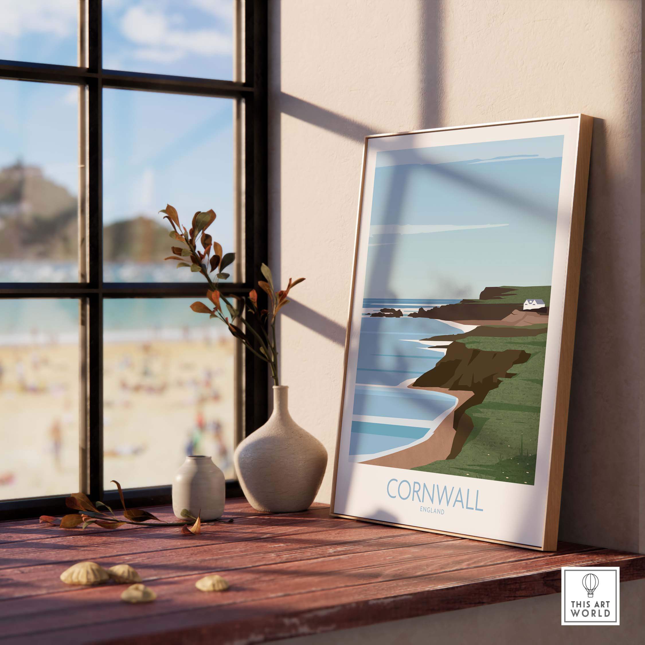 Cornwall Poster Print featuring coastal scenery, placed on a wooden table by a window, adding style to home decor.