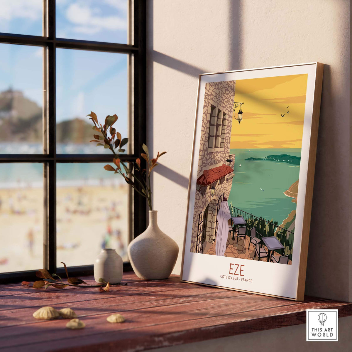 Eze Print France Travel Poster framed on a wooden shelf by a window, showcasing coastal scenery and vintage travel art.