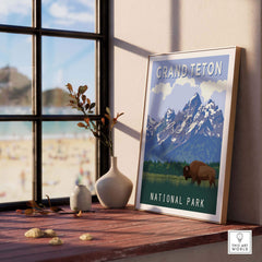 Framed Grand Teton National Park print on a wooden table, showcasing mountains and wildlife in a stylish home setting.
