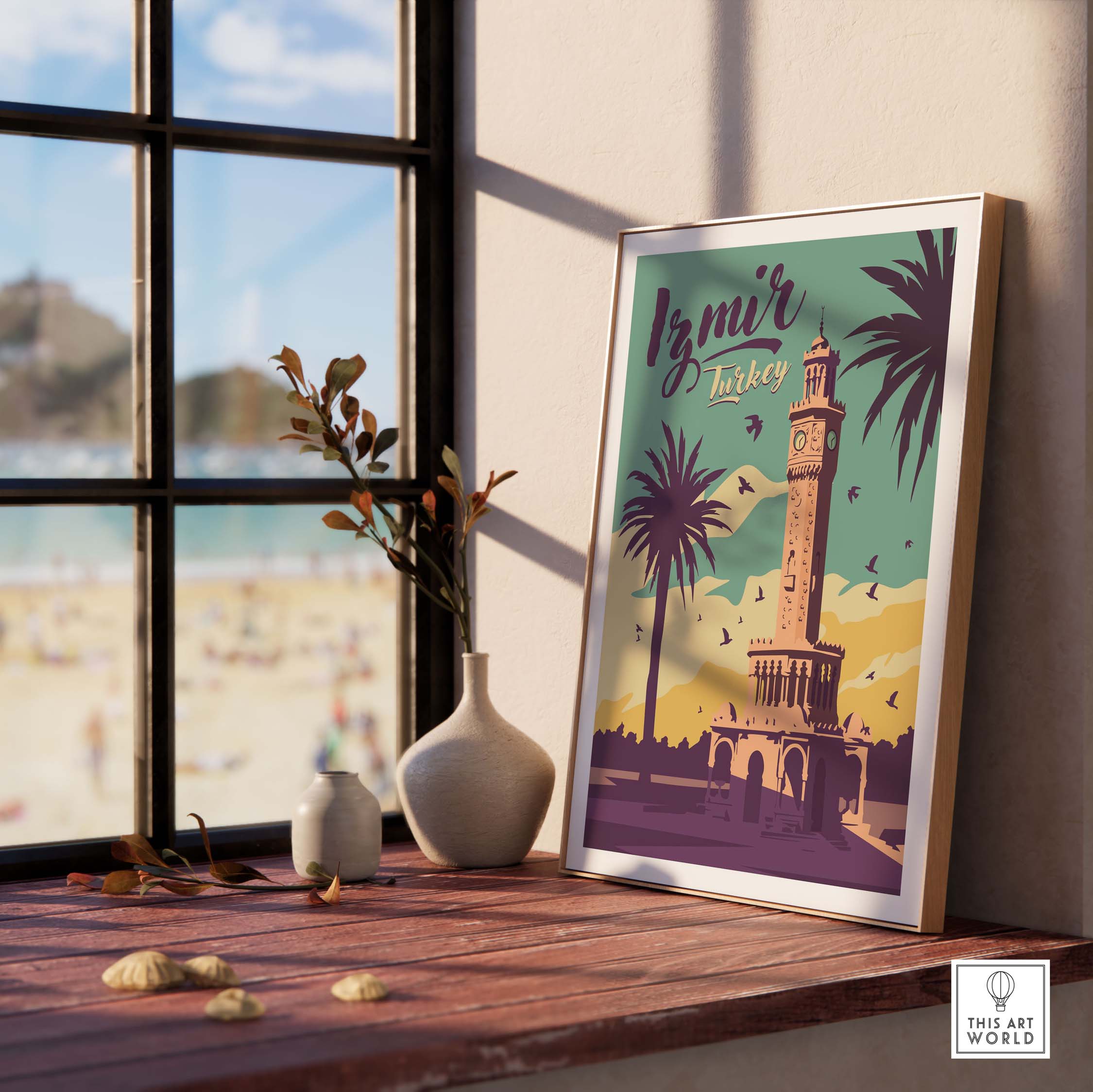 Izmir Print Turkey Travel Poster displayed on a wooden table with plants and a beach view in the background.