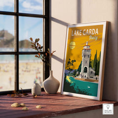 Lake Garda Print Italy poster displayed on a windowsill with a beach view, ideal for home or office decor.