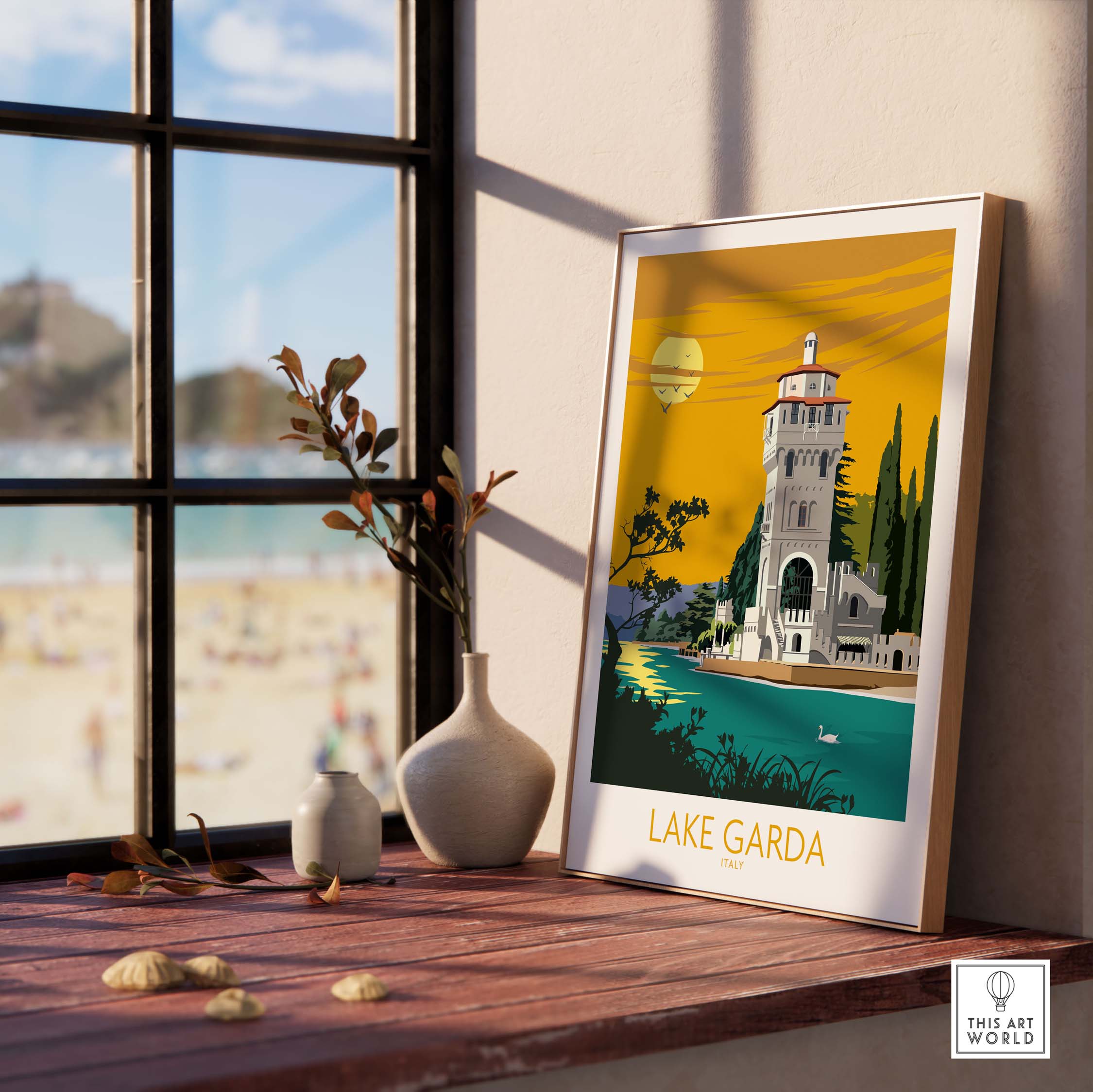 Lake Garda Italy poster print displayed on a wooden table by a window with beach view, showcasing vintage travel design.