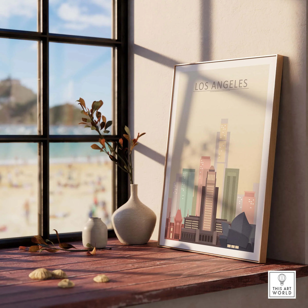 Los Angeles skyline poster displayed on a wooden table near a window, featuring colorful city buildings and beach view.