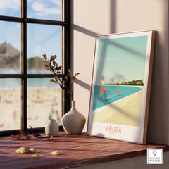 Aruba Caribbean poster featuring flamingos and beach scene, displayed on a windowsill with decorative vase and plants.