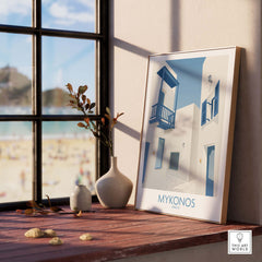 Mykonos wall art print displayed by a sunny window, showcasing vintage travel poster style with blue and white architecture.