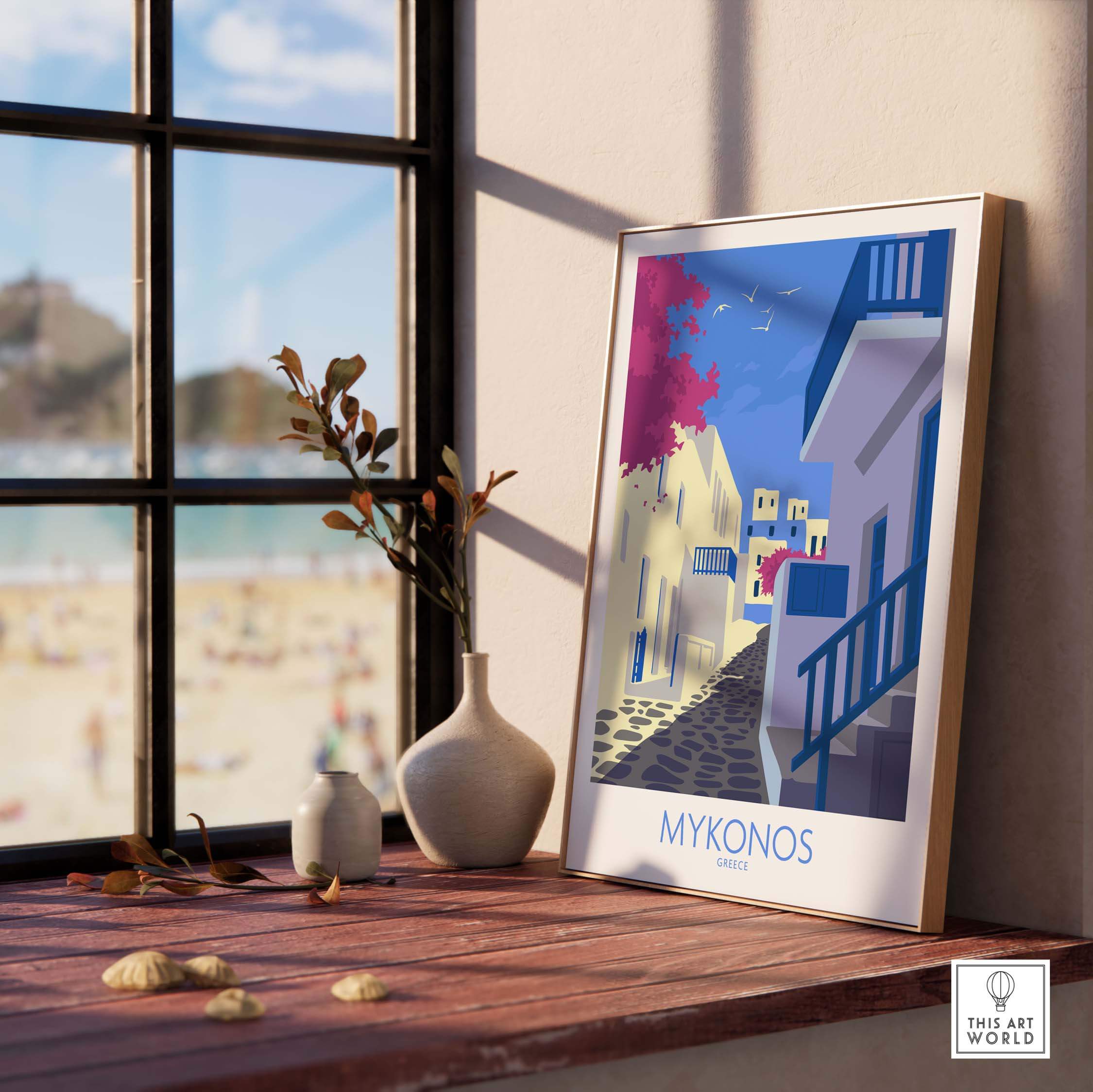 Stylish Mykonos print travel poster displayed on a wooden table with a coastal view, enhancing home decor.