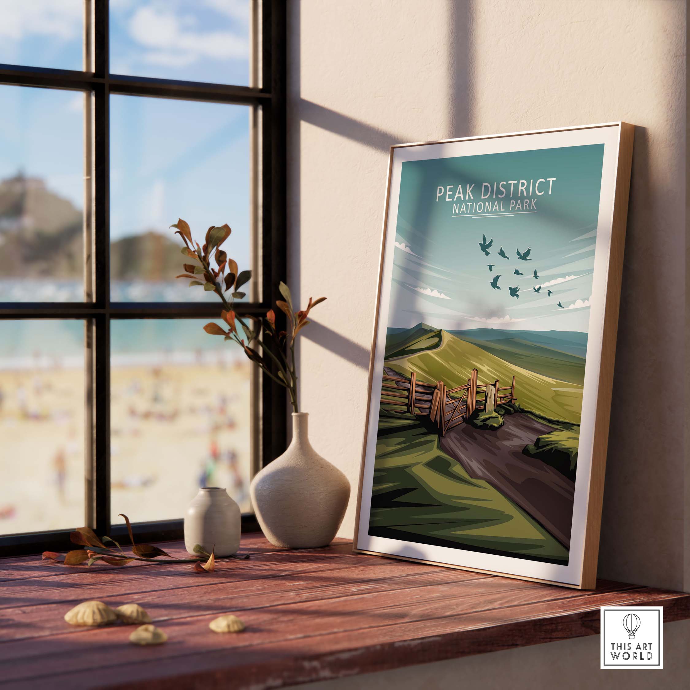 Minimalist Peak District National Park poster displayed in a sunny room with plants and a beach view.