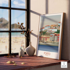 Porto Wall Art Portugal Print displayed by a window, featuring colorful buildings and beach view, perfect for home decor.