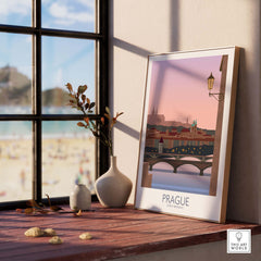 Prague travel print poster displayed on wooden table near a window, showcasing romantic cityscape and vintage design.