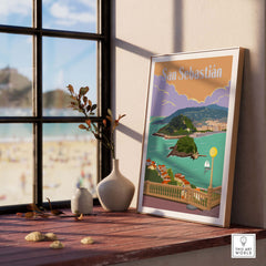 San Sebastian Spain poster print displayed indoors by a window, showcasing a scenic coastal view.