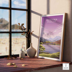 Framed Snowdonia National Park poster on a wooden table with a vase and stones, showcasing minimalist nature art.