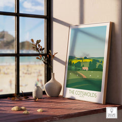 Stylish Cotswolds print travel poster framed by a window, showcasing England's scenic countryside.
