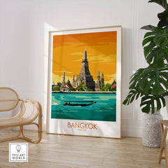 Bangkok travel poster featuring a vibrant illustration of Wat Arun and a boat on the Chao Phraya River, framed in a stylish interior.