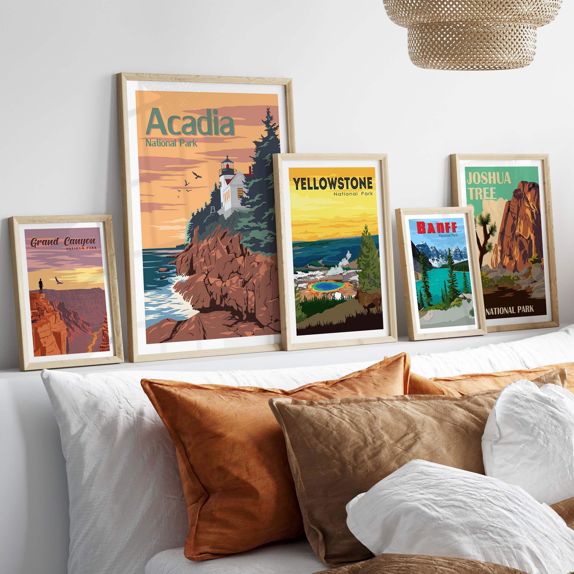 Framed vintage-style Acadia National Park poster with other National Park artworks on display above a cozy bed.