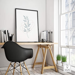 Modern leaf art print framed on wall above stylish office desk with books and greenery, adding a fresh touch to decor.