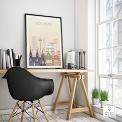 Cologne skyline print in warm pastel tones displayed in a stylish workspace, showcasing the city's iconic architecture.