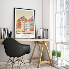 Denmark Poster Art Print displayed on a desk in a minimalist workspace, featuring colorful vintage architectural design.
