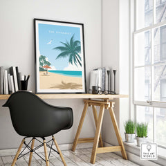 The Bahamas travel poster print featuring a beach scene with palm trees, framed in a modern home office.