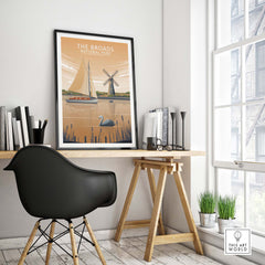 The Broads National Park poster displayed in a stylish home office setting, featuring boats and a windmill.