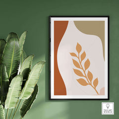Leaf wall art print in a modern frame, enhancing a green wall decorated with a lush plant.