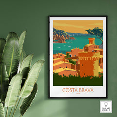 Costa Brava poster featuring a coastal scene in Spain, framed on a green wall with tropical leaves.