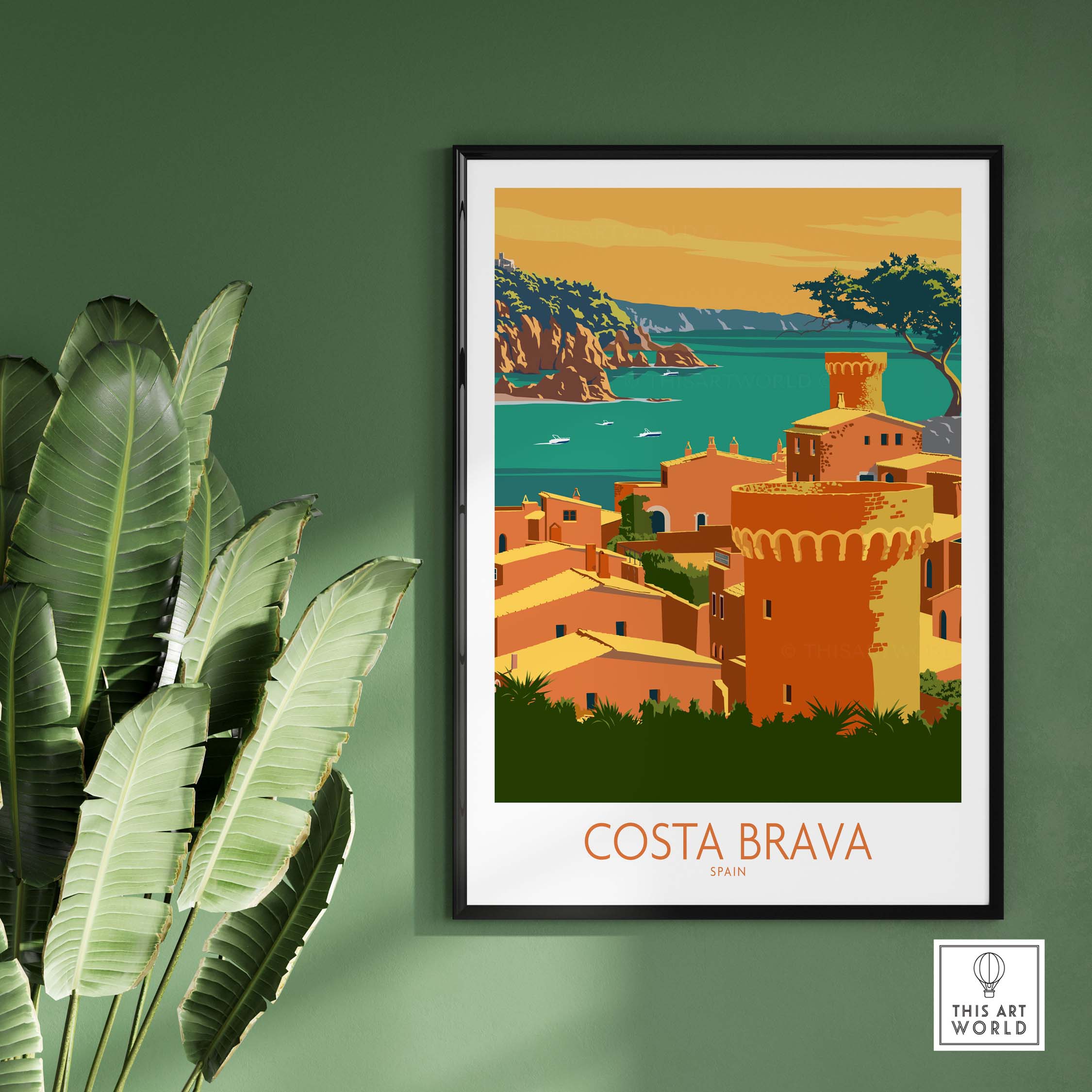 Costa Brava poster featuring a coastal scene in Spain, framed on a green wall with tropical leaves.