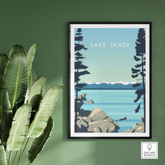 Lake Tahoe Print Wall Art Poster with vintage design, framed, against green wall and tropical leaves.