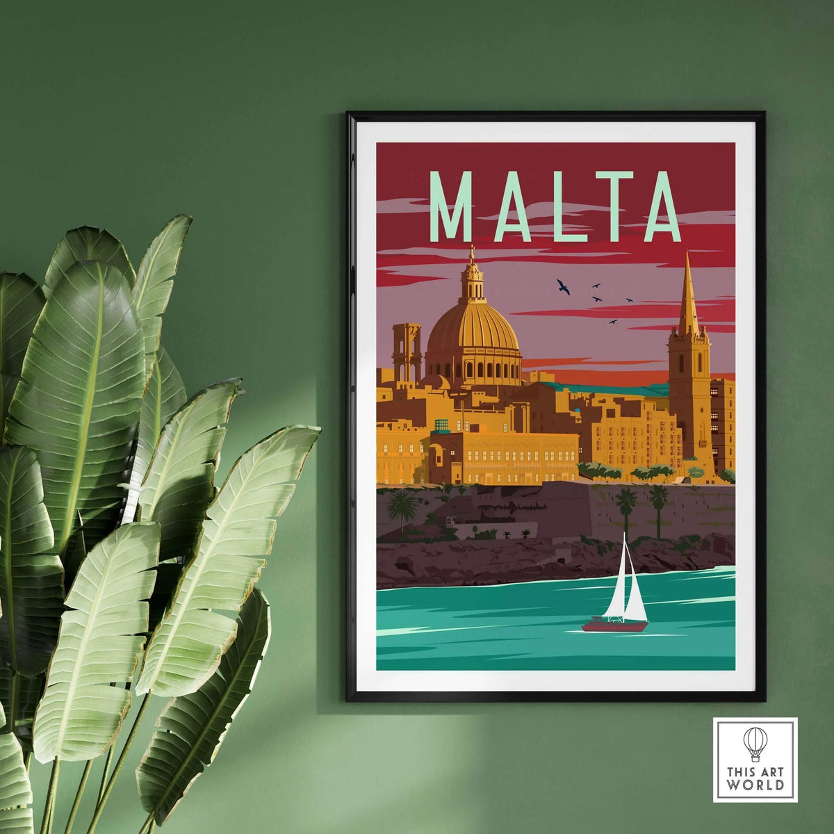 Malta vintage travel poster print framed on green wall with palm leaves and sailboat on water.