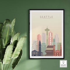 Seattle city skyline print in pastel tones, framed art piece displayed on a green wall with indoor plant.