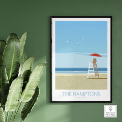 The Hamptons vintage travel wall art print framed on a green wall, featuring a lifeguard chair and beach scene.